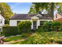 Charming home with manicured front yard, trimmed hedges, and gray front door at 522 Trabert Nw Ave, Atlanta, GA 30309