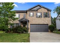 Charming two-story brick home featuring a two-car garage and a well-maintained front yard with lush landscaping at 468 Lake Ridge Ln, Fairburn, GA 30213