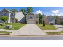 Charming two-story home with a stone-accented facade, well-manicured lawn, and a concrete driveway at 104 Auburn Crossing Way, Auburn, GA 30011