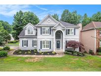Charming two-story home featuring a manicured lawn and classic architectural details at 200 Ridge Bluff Ln, Suwanee, GA 30024