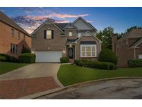 Charming two-story brick home with well-manicured lawn and a brick-lined driveway at 2321 Norbury Se Cv, Smyrna, GA 30080