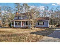 Charming two-story home featuring a cozy front porch and a red front door at 130 Thornton Dr, Fayetteville, GA 30214
