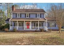 Charming two-story home with a welcoming front porch and a vibrant red front door at 130 Thornton Dr, Fayetteville, GA 30214