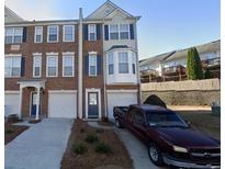 Charming brick townhome with blue shutters and a well-maintained front yard and a truck parked in the driveway at 3263 Mill Springs Circle Northeast Cir, Buford, GA 30519