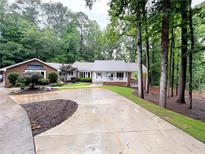 Charming single-Gathering home boasts lush landscaping, a spacious driveway, and a tranquil wooded setting at 630 Buttercup Trce, Johns Creek, GA 30022