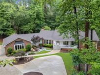 Charming brick home with lush landscaping, a circular driveway and a covered front porch at 630 Buttercup Trce, Johns Creek, GA 30022