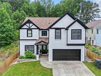 Two story home featuring a two-car garage, black trim, and manicured front lawn at 2111 Nelms Pointe Lndg, Lawrenceville, GA 30043
