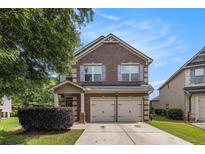 Charming brick two-story home featuring a two-car garage and manicured lawn at 2149 Apple Orchard Way, Austell, GA 30168