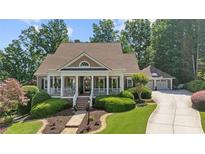 Charming home with a welcoming front porch, manicured landscaping, and a long driveway leading to a two-car garage at 3902 Butterstream Way, Kennesaw, GA 30144