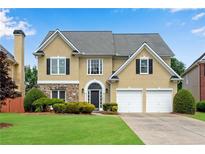 Traditional two-story home boasts a manicured lawn and a two-car garage at 1712 Bonnabel Ne Trce, Marietta, GA 30066