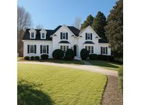 Elegant white home featuring a manicured lawn, dark shutters, and a welcoming curved driveway at 110 Glen Eagle Way, Mcdonough, GA 30253