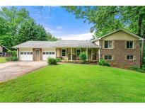 Charming two-story home with brick and siding exterior and a well-manicured lawn, plus a two-car garage at 486 Buttercup Trl, Lawrenceville, GA 30046