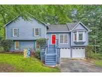 Charming two-story home with blue siding, a red door, and a well-maintained lawn at 2715 Braemore Gln, Powder Springs, GA 30127