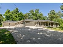 Ranch home with a three-car garage, lush landscaping and a long driveway with ample parking space at 762 Rockbridge Nw Rd, Lilburn, GA 30047