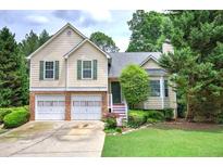 Charming two-story home with a two-car garage, well-manicured lawn and lush landscaping at 1047 Taso Trl, Acworth, GA 30101