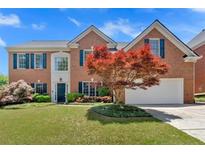 Charming brick two-story home with manicured lawn and mature landscaping, perfect for curb appeal at 2372 Oberon Se Walk, Smyrna, GA 30080