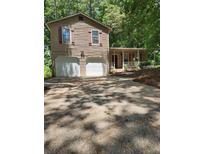 Charming two-story home with a spacious driveway and a welcoming front porch at 5389 Martins Crossing Rd, Stone Mountain, GA 30088