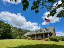 Charming brick home featuring a large lawn, mature trees and inviting covered front porch at 238 Marks Rd, Mansfield, GA 30055