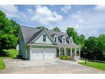 Charming two-story home with a two-car garage, covered porch, and well-manicured lawn at 410 Hendon Rd, Woodstock, GA 30188