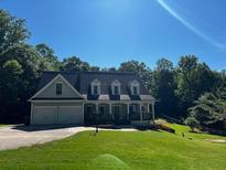 Charming home with a well-maintained front lawn, attached two-car garage, and covered front porch at 410 Hendon Rd, Woodstock, GA 30188