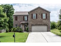 Charming two-story brick home featuring a well-maintained front yard, attached garage, and traditional design at 8553 Braylen Manor Dr, Douglasville, GA 30134