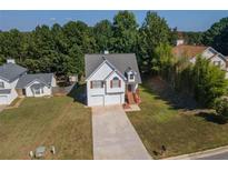 Charming two-story home with a two-car garage, landscaped yard, and a welcoming front entrance at 10074 Tara Glynn Dr, Hampton, GA 30228