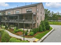 Stunning brick townhome with covered patios and manicured landscaping, located on a corner lot at 6460 Cortland Walk, Alpharetta, GA 30005