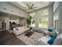 Bright living room with large windows, a ceiling fan, hardwood floors, and an open floor plan into the kitchen at 1207 Summit North Ne Dr # 1207, Atlanta, GA 30324