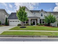 Charming two-story home with manicured lawn, inviting curb appeal, and attached two car garage at 1891 Primrose Park Rd, Sugar Hill, GA 30518