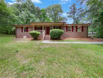 Charming single-story brick home with mature landscaping and a welcoming front porch at 20 Shadow Creek Dr, Villa Rica, GA 30180