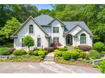 Elegant home featuring manicured landscaping and a charming facade, surrounded by mature trees at 312 Crabapple Springs Way, Woodstock, GA 30188