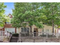 Inviting two-story townhome featuring mature trees and a charming wood porch and facade at 112 Hawkeye Ln, Conyers, GA 30012