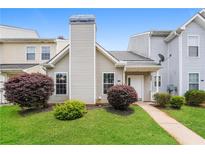 Charming townhouse featuring lush front lawn and neatly trimmed shrubbery at 5867 Trent Walk Dr, Lithonia, GA 30038