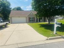 Charming single-story home with a well-manicured lawn, concrete driveway, and attached garage at 35 Creek Bend Trl, Oxford, GA 30054