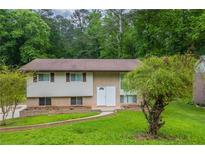 Charming split-level home with a well-maintained front lawn and a brick facade, nestled among mature trees at 4345 Kimball Sw Rd, Atlanta, GA 30331