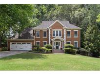 Beautiful two-story brick home with a well-manicured lawn and a two-car garage at 4648 Equestrian Way, Atlanta, GA 30338