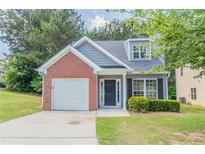 Charming home featuring a brick facade, manicured lawn, garage, and inviting entrance at 4695 Ravenwood Loop, Union City, GA 30291