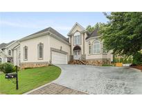 Stately home featuring manicured lawn, stone accents, and a three-car garage at 4770 Powers Park Ne Ct, Marietta, GA 30067