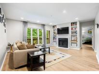 Bright living room features a fireplace, built-in shelves, and access to a balcony with wooded views at 472 Sherman Way, Decatur, GA 30033
