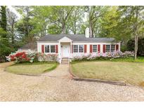 Charming one story home featuring blooming azaleas, red shutters, and mature trees at 70 Mount Paran Ne Rd, Atlanta, GA 30342