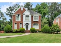 Charming brick home featuring a manicured lawn and lush landscaping at 470 Manor Oak Se Ln, Marietta, GA 30067