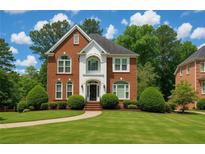Beautiful two-story brick home featuring a manicured lawn, lovely landscaping and a classic architectural design at 470 Manor Oak Se Ln, Marietta, GA 30067