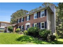 Charming two-story brick home with black shutters and a well-manicured lawn at 1956 Spencer Oaks Ln, Lithonia, GA 30058