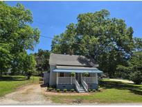 Charming single-story home with a quaint front porch and mature trees, offering a cozy and inviting curb appeal at 5108 Hackett Ne St, Covington, GA 30014