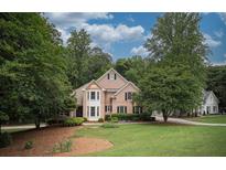 Charming two-story brick home with a well-manicured lawn and mature trees offering great curb appeal at 1325 Starboard Way, Cumming, GA 30041