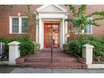 Charming brick building entrance featuring a striking red door with white columns, steps, and manicured landscaping at 733 Frederica Ne St # 17, Atlanta, GA 30306