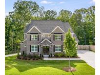 Charming two-story brick home featuring manicured lawn, stone accents, and a welcoming entrance at 771 Phil Haven Ln, Kennesaw, GA 30152