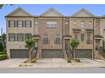 Beautiful townhome exterior featuring brick facade, two-car garage, and well maintained front yard at 1582 Cambridge Pl, Marietta, GA 30062