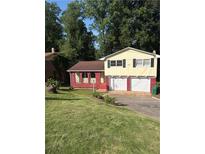 Split level home with red brick and siding, a two car garage, and a driveway at 801 Needle Rock Dr, Stone Mountain, GA 30083