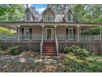 Charming two-story home featuring a welcoming front porch, neutral siding and well-maintained landscaping at 143 Cotton Mill Dr, Hiram, GA 30141